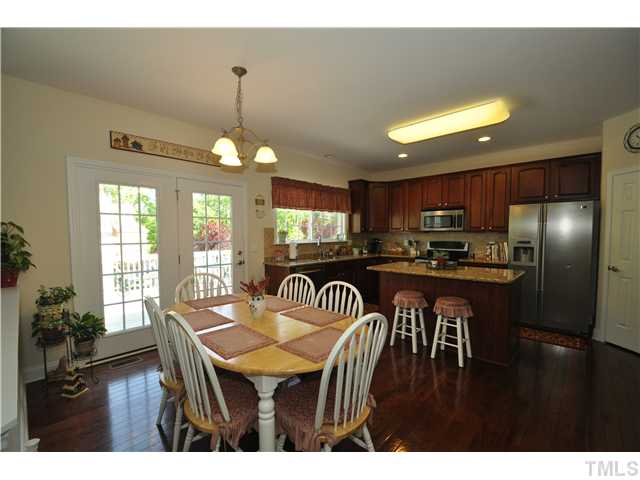 2109 Wide River Drive Raleigh, NC 27614 - Photo 9 of 20 a kitchen with a table chairs refrigerator and microwave