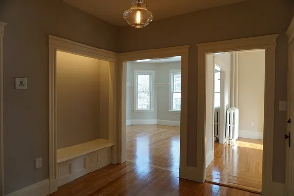 a view of a hallway with wooden floor and glass door
