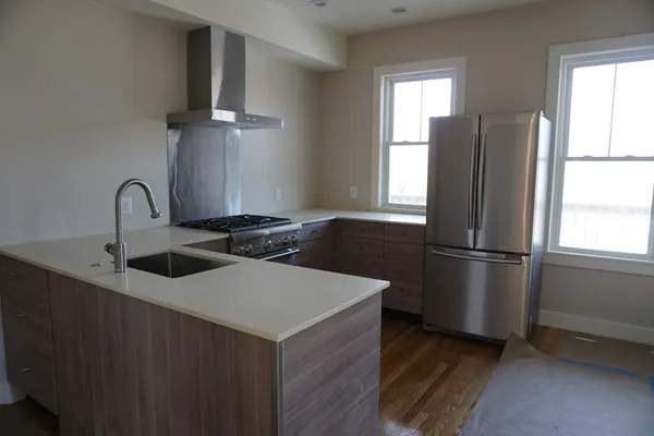 a kitchen with stainless steel appliances a refrigerator a sink a stove and a refrigerator