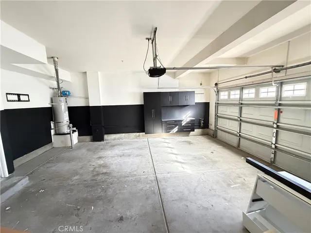 an empty room with wooden floor cabinet and windows