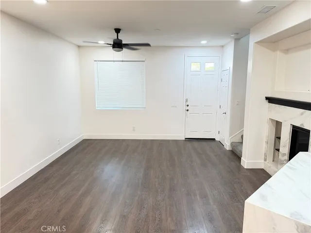 an empty room with wooden floor cabinet and windows