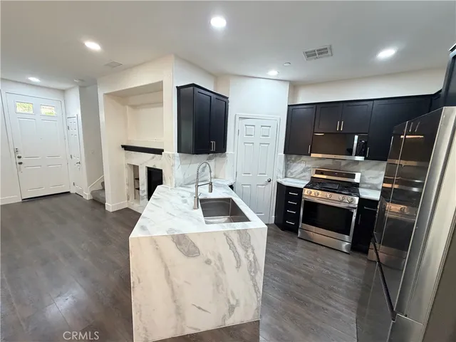 a kitchen with stainless steel appliances a refrigerator stove microwave and sink