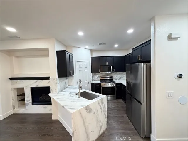 a kitchen with stainless steel appliances granite countertop a sink stove and refrigerator