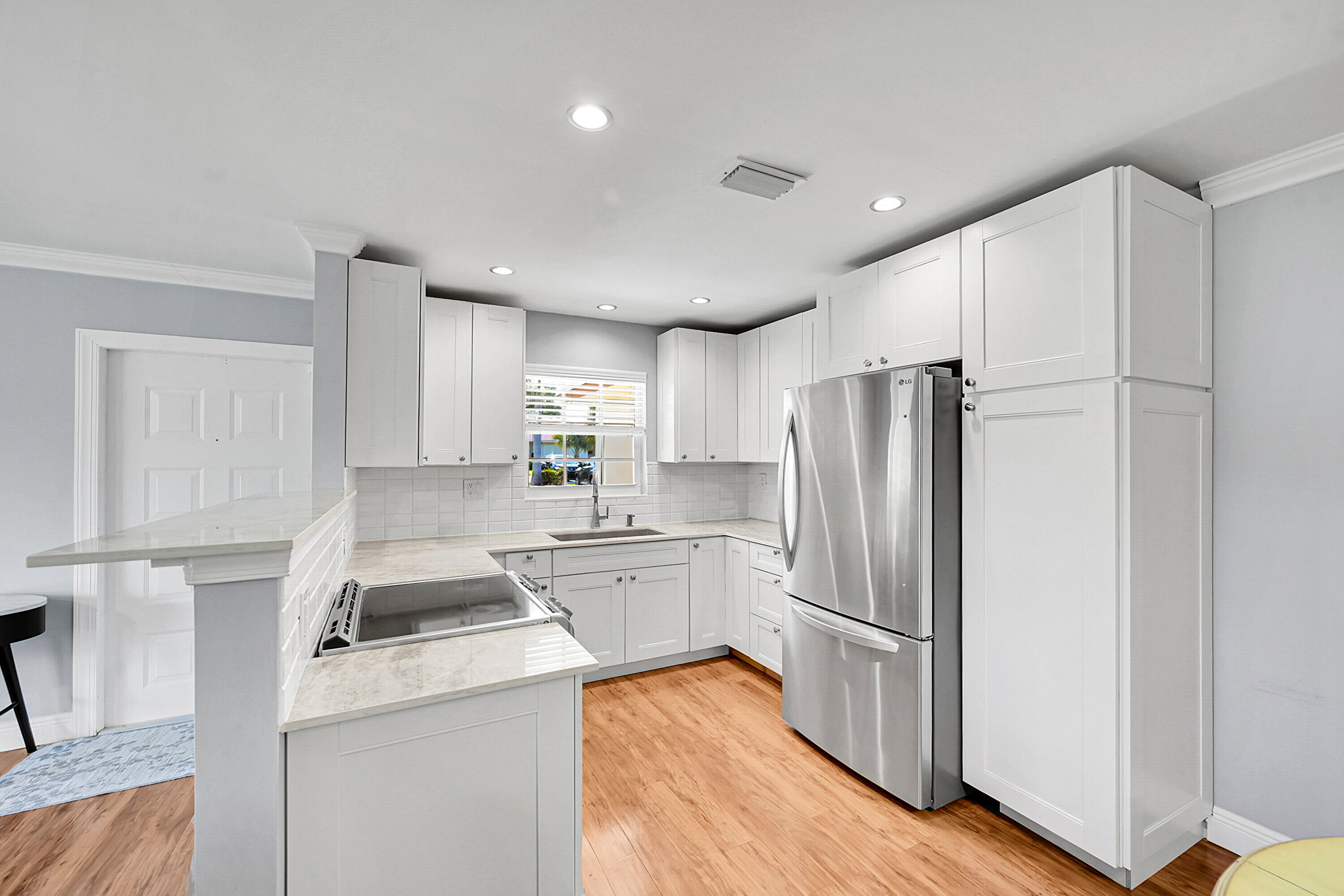4585 Northwest 3rd Street, Unit D Delray Beach, FL 33445 - Photo 16 of 45 a kitchen with a refrigerator a stove and wooden floor