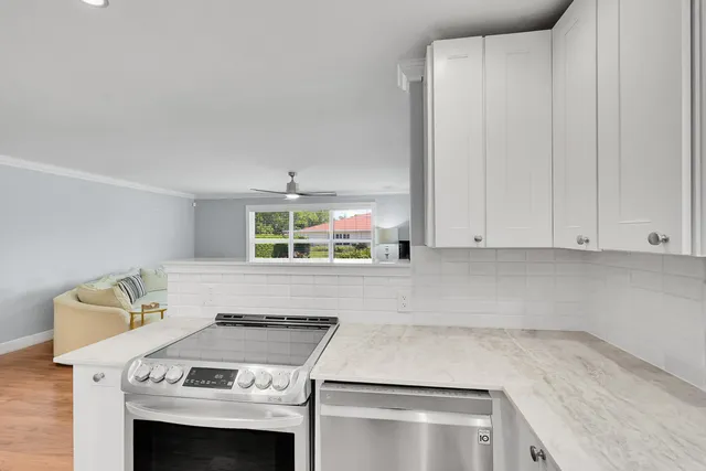 a kitchen with a refrigerator a stove and wooden floor