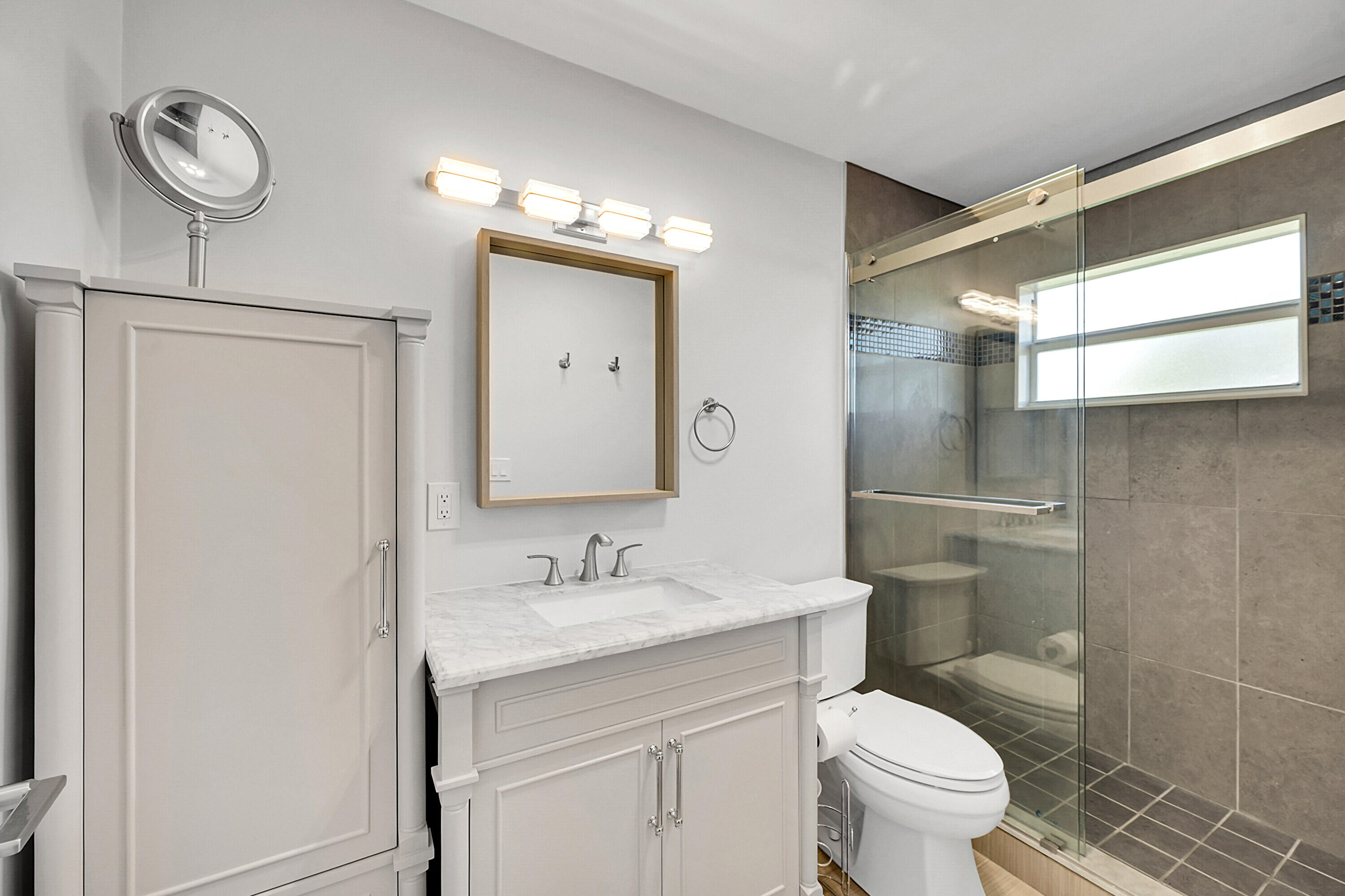 4585 Northwest 3rd Street, Unit D Delray Beach, FL 33445 - Photo 24 of 45 a bathroom with a toilet sink and mirror