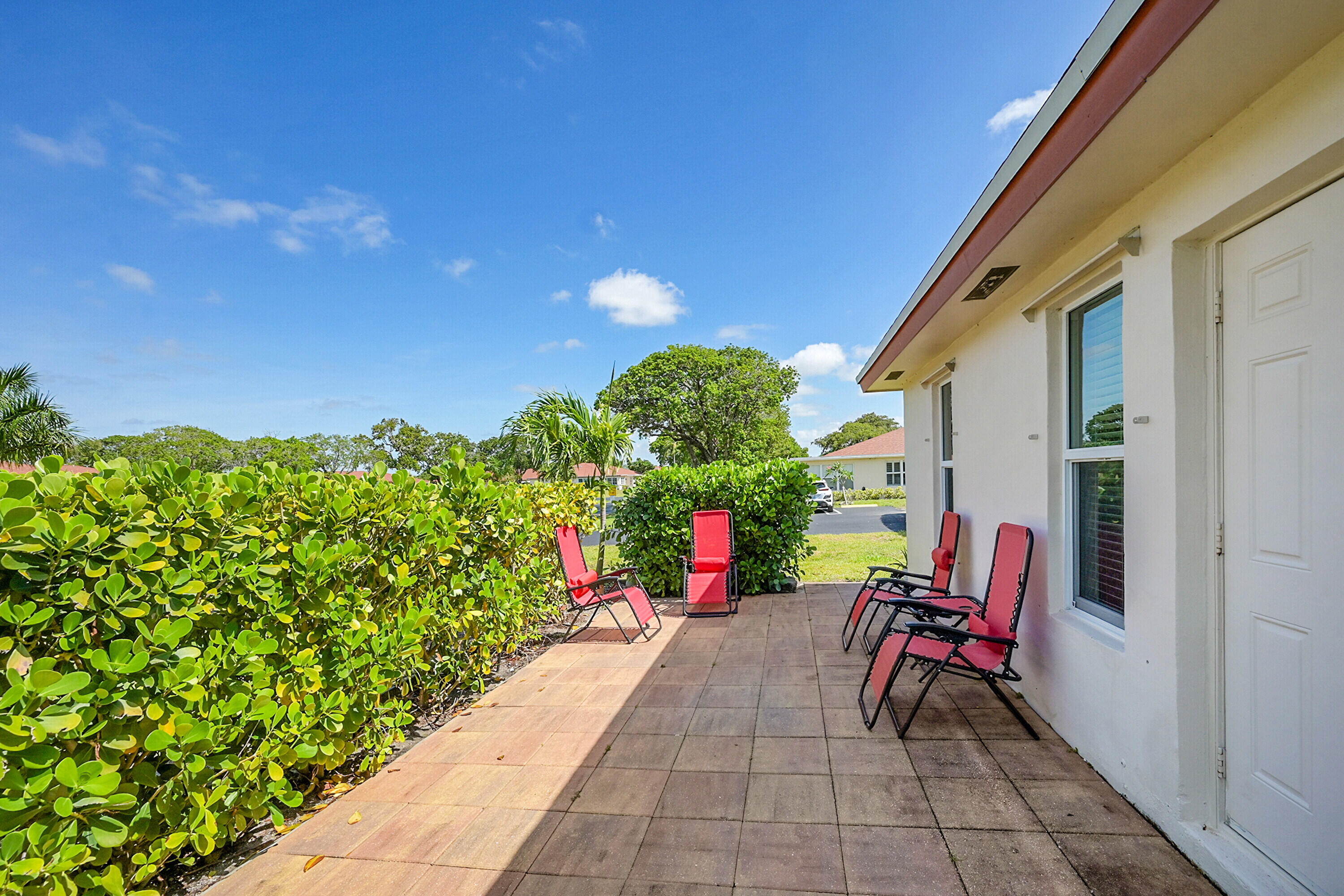 4585 Northwest 3rd Street, Unit D Delray Beach, FL 33445 - Photo 30 of 45 a view of a chairs and table in the back yard of the house