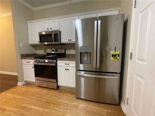 a kitchen with stainless steel appliances a refrigerator stove and microwave