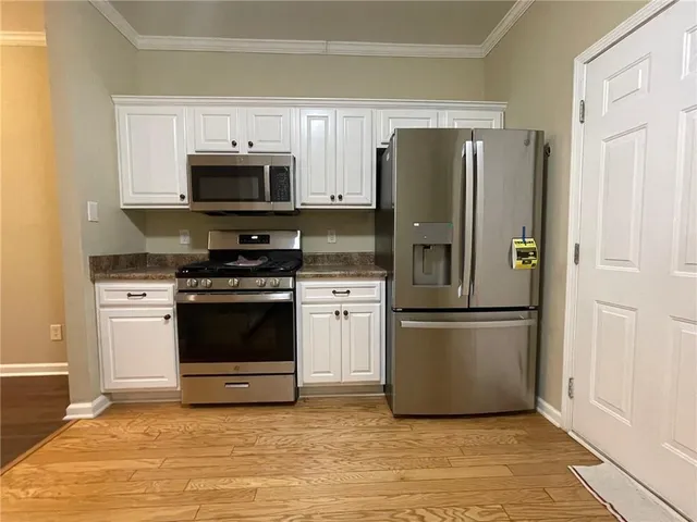 a kitchen with stainless steel appliances a refrigerator stove and microwave