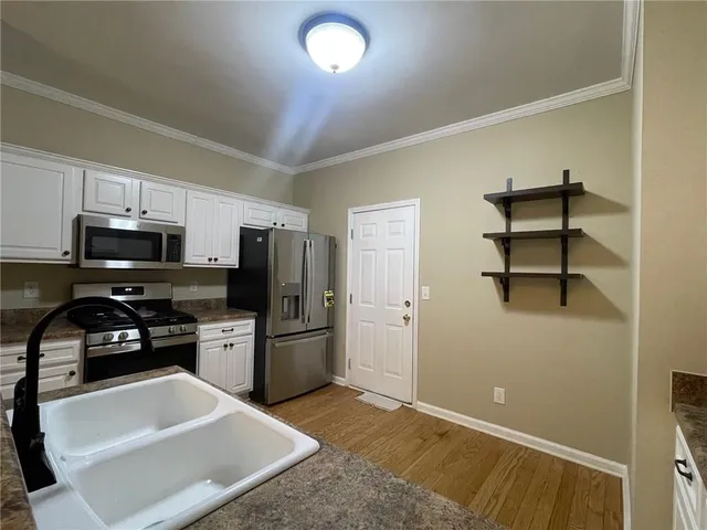 a kitchen with granite countertop a refrigerator and a stove top oven