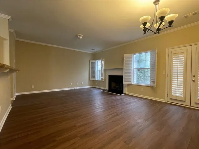 a view of empty room with wooden floor and fireplace