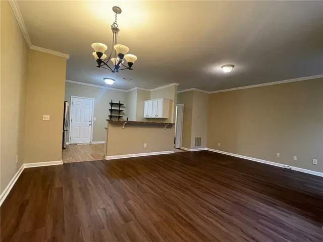 a view of a room with wooden floor and chandelier