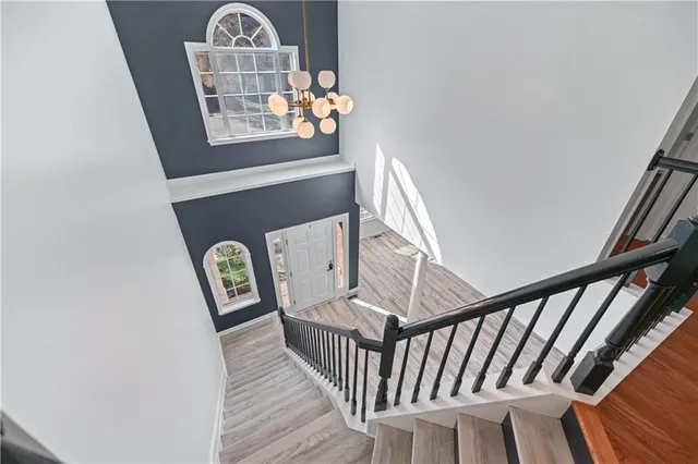 a view of staircase with wooden floor and wall painting