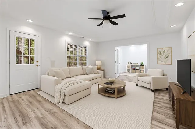 a living room with furniture ceiling fan and a window