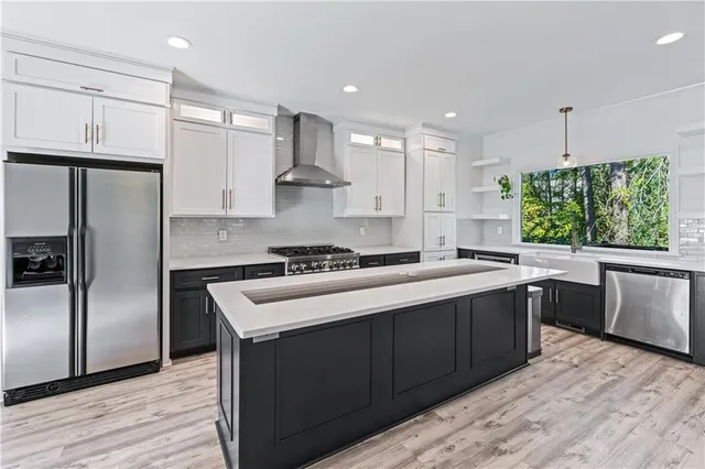 a kitchen with stainless steel appliances granite countertop a sink stove and refrigerator