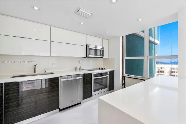 a kitchen with stainless steel appliances a sink stove and refrigerator