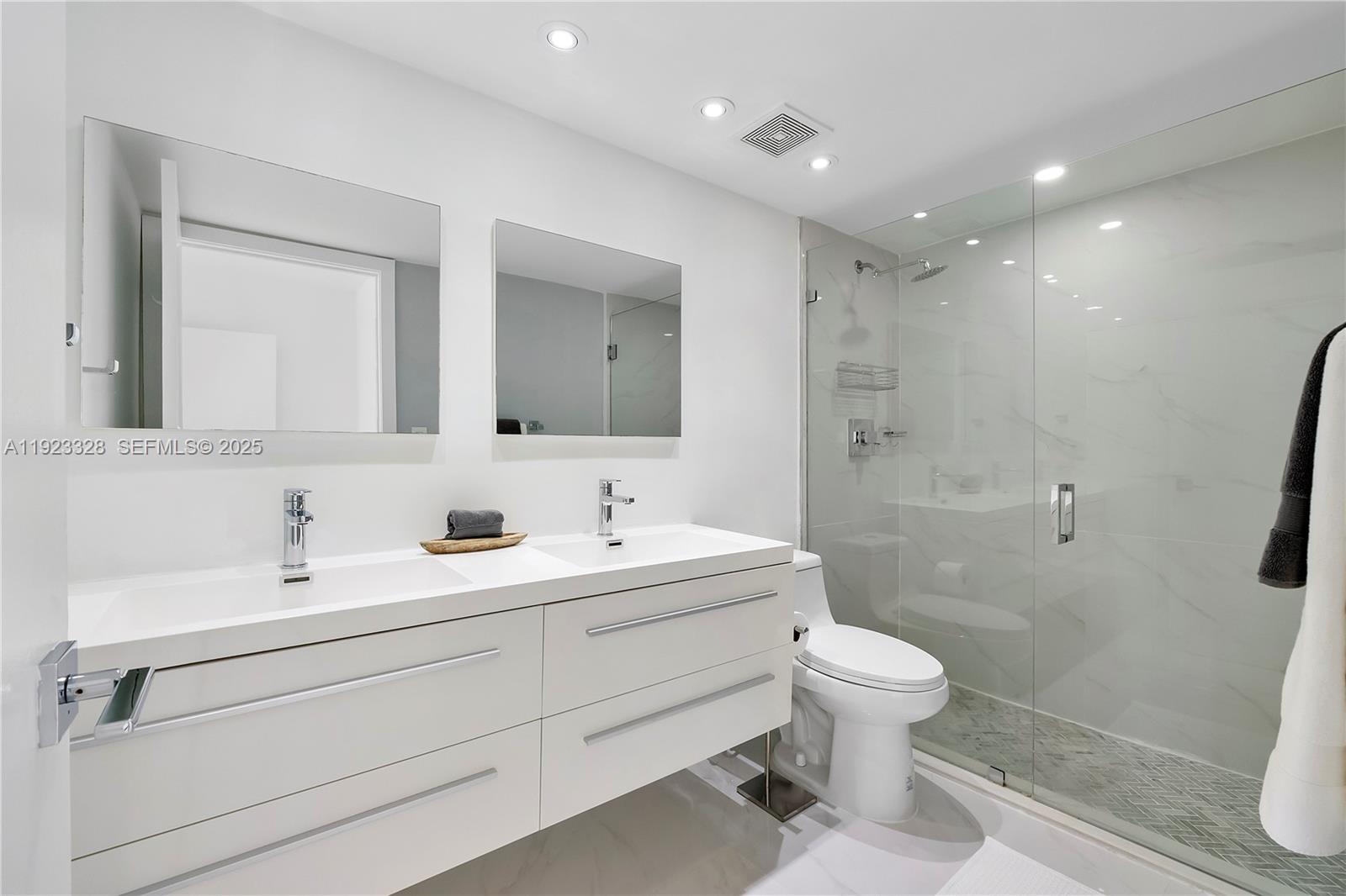 780 Northeast 69th Street, Unit 1601 Miami, FL 33138 - Photo 7 of 18 a bathroom with a toilet a sink a mirror and a shower