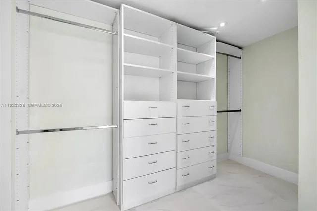 a kitchen with stainless steel appliances a refrigerator a stove a sink and chairs