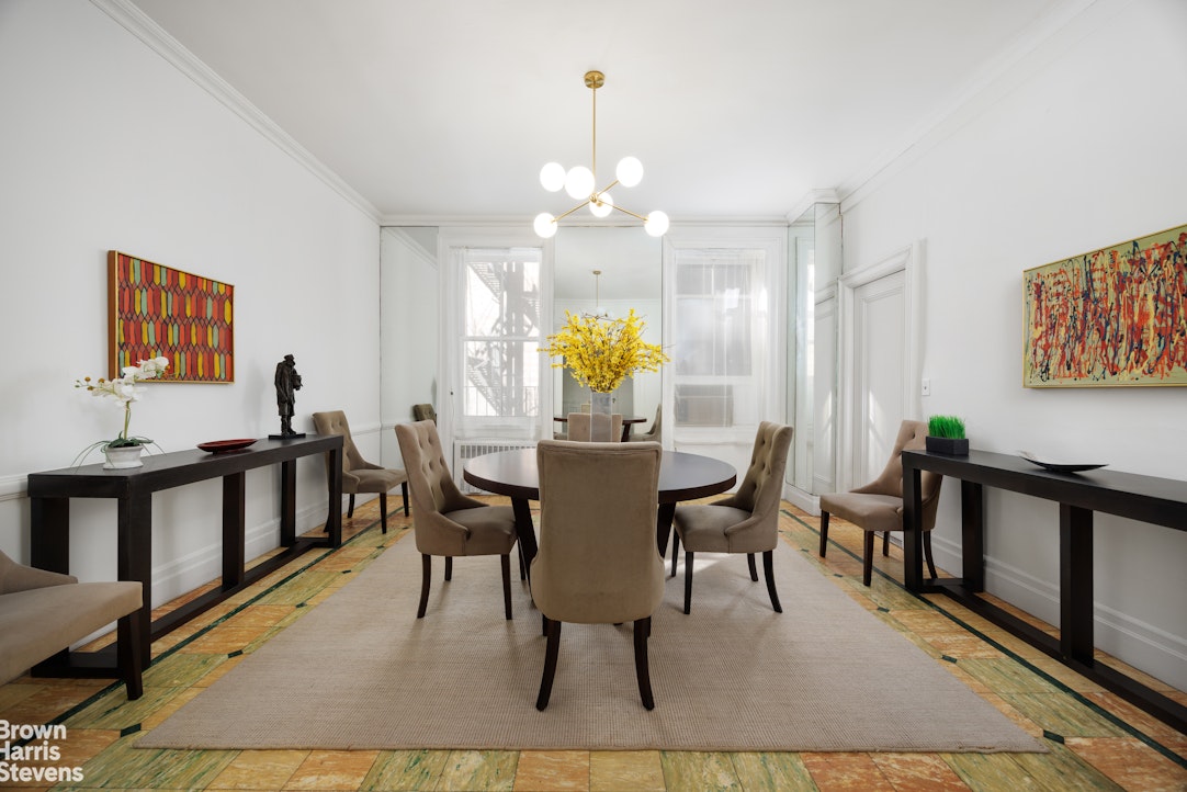 32 East 64th Street, Unit 2E Manhattan, NY 10065 - Photo 5 of 9 a view of a dining room with furniture a chandelier and wooden floor