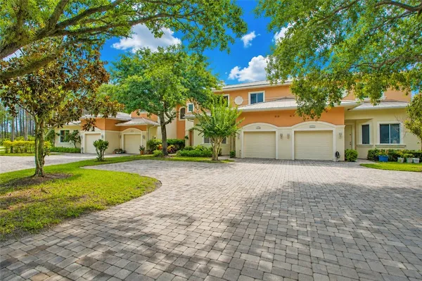 a front view of a house with a yard and trees