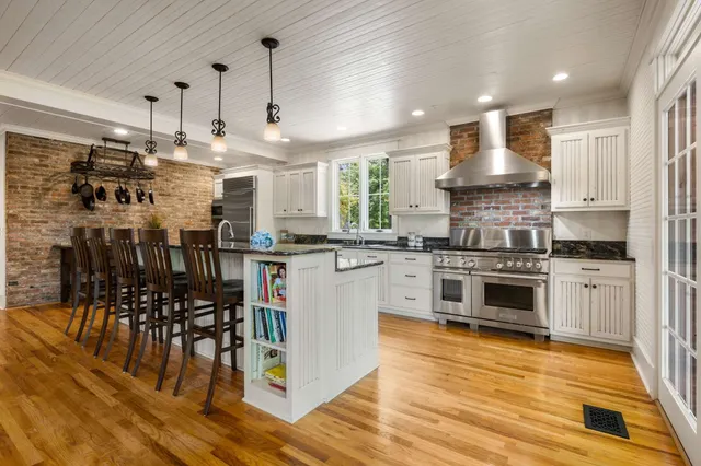 a kitchen with kitchen island granite countertop a sink cabinets and wooden floor