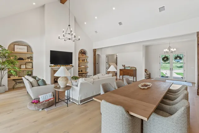 a living room with furniture a flat screen tv and a chandelier