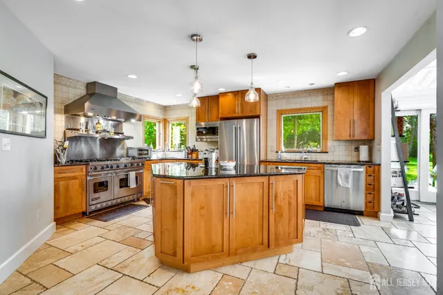 a kitchen with stainless steel appliances granite countertop sink stove top oven and cabinets