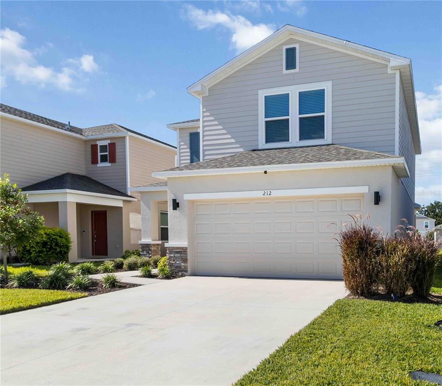 a front view of a house with a yard and garage