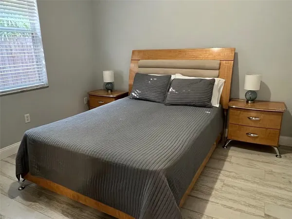 a bedroom with a bed and wooden floor