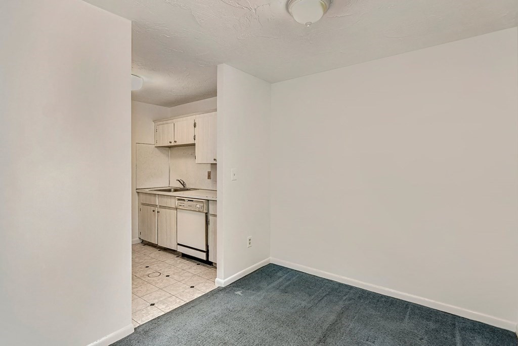 53 Will Drive, Unit 140 Canton, MA 02021 - Photo 4 of 22 a kitchen with granite countertop white cabinets and white appliances