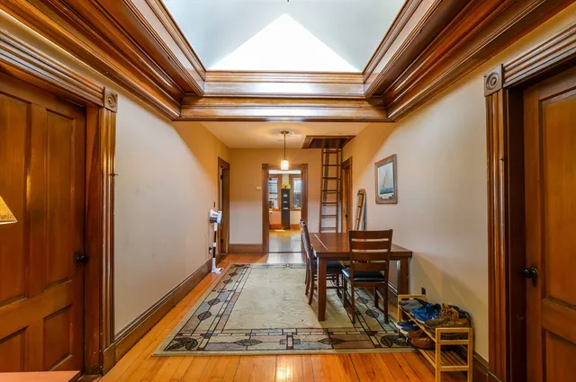 a view of a hallway with wooden floor and furniture