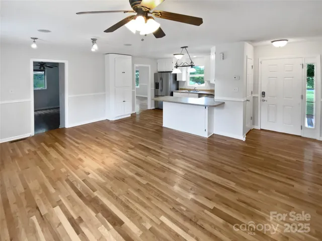 a open kitchen with kitchen island white cabinets and stainless steel appliances