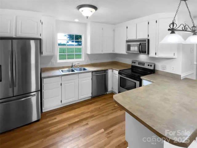 a kitchen with stainless steel appliances granite countertop a stove a sink dishwasher a refrigerator and a microwave
