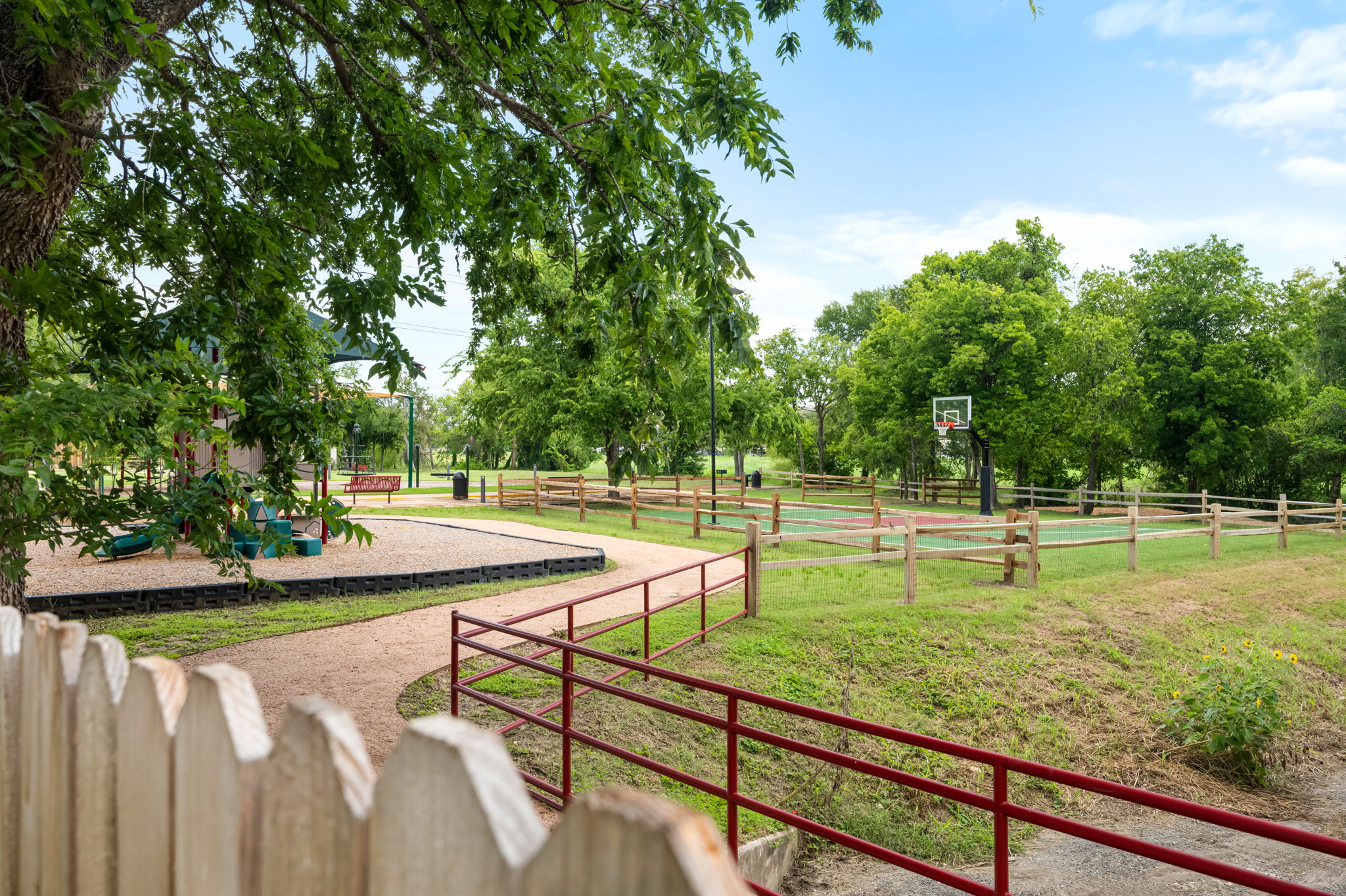 1408 Water Spaniel Way Round Rock, TX 78664 - Photo 32 of 37 A community recreation area features a vibrant playground and a well-maintained basketball court, offering leisure for all.