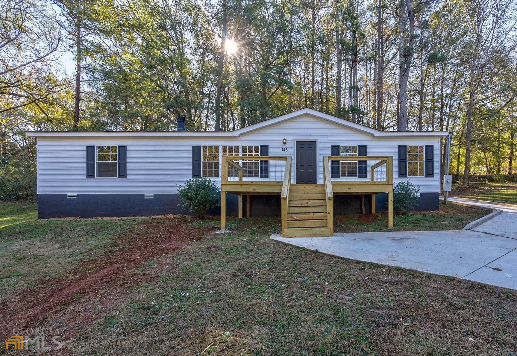 145 Woodbine Street Commerce, GA 30529 - Photo 1 of 1 a view of a house with a yard and large trees