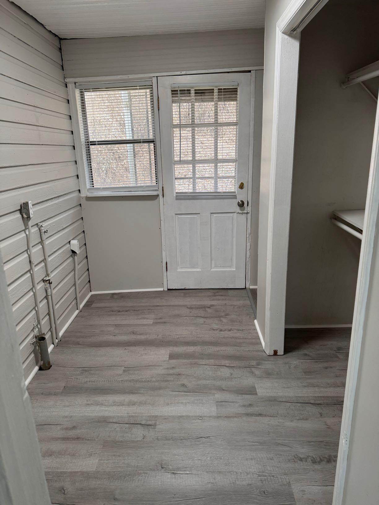 711 Barrows Mill Road Martinsville, VA 24112 - Photo 2 of 10 an empty room with wooden floor and windows