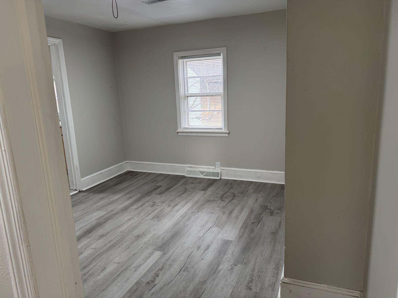 711 Barrows Mill Road Martinsville, VA 24112 - Photo 7 of 10 an empty room with wooden floor and windows
