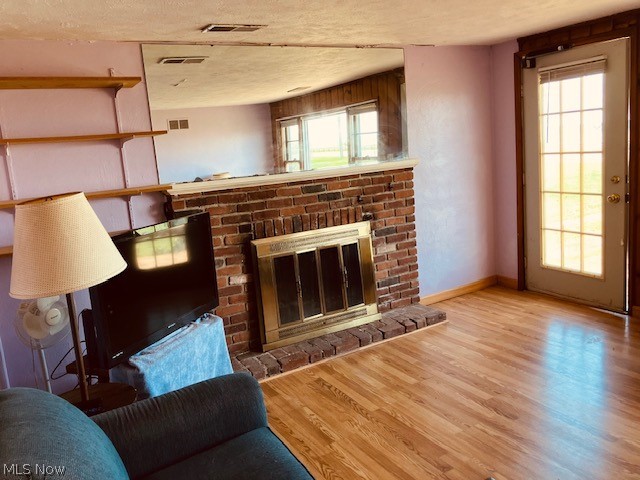 4374 Lake Road East Geneva, OH 44041 - Photo 10 of 19 Living room featuring a textured ceiling, a fireplace, and hardwood / wood-style flooring