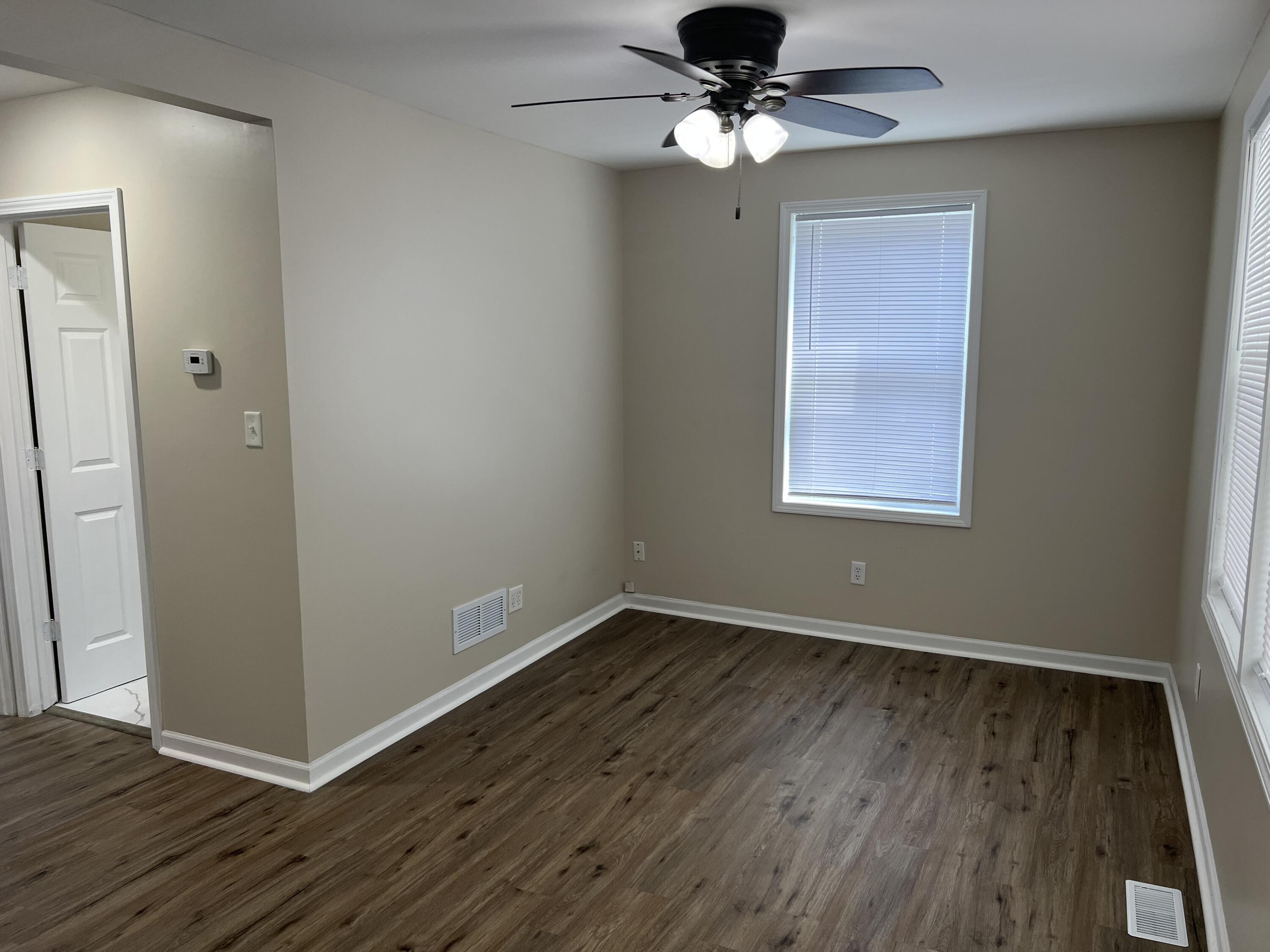 3851 Maple Street Hobart, IN 46342 - Photo 2 of 28 an empty room with wooden floor fan and windows