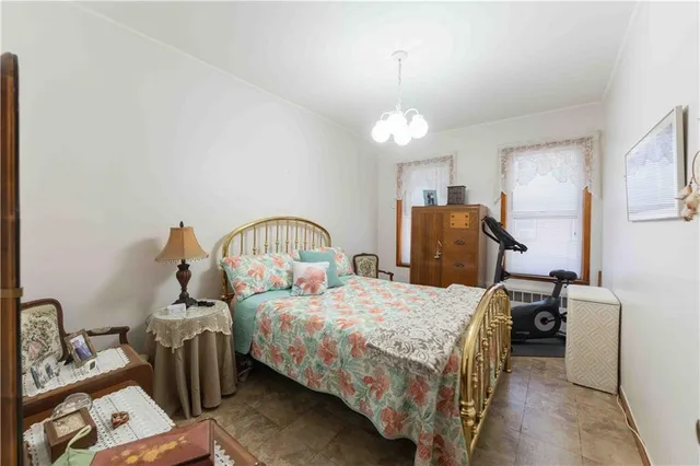 a bedroom with bed and a chandelier