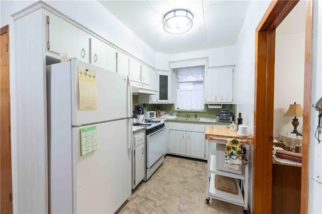 a kitchen with stainless steel appliances a refrigerator sink and white cabinets