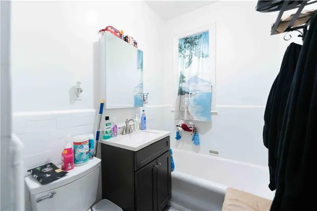 a bathroom with a sink vanity mirror and a bathtub