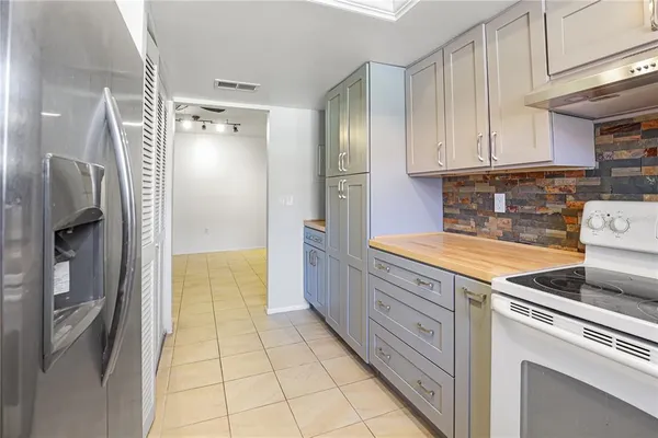 a kitchen with granite countertop a refrigerator and a stove top oven