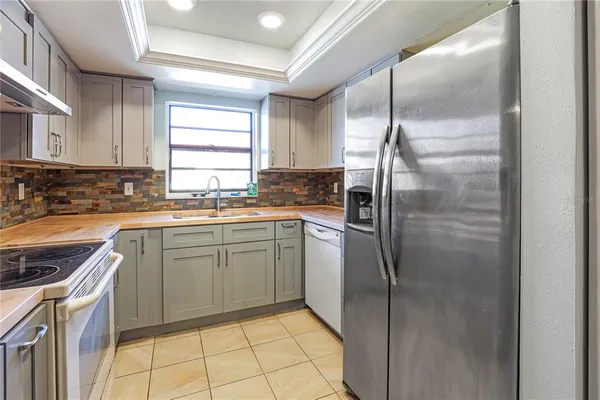 a kitchen with a refrigerator sink and cabinets