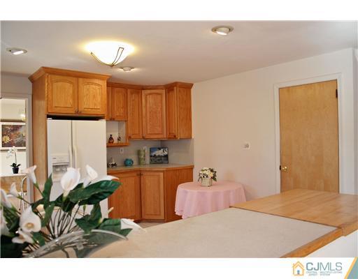 19 Timber Road Edison, NJ 08820 - Photo 20 of 25 a kitchen with a table chairs refrigerator and cabinets