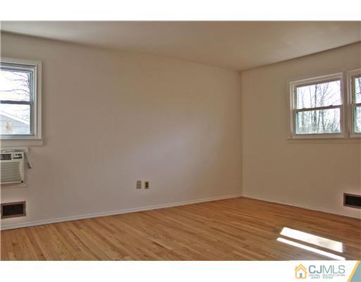 19 Timber Road Edison, NJ 08820 - Photo 9 of 25 an empty room with wooden floor and windows
