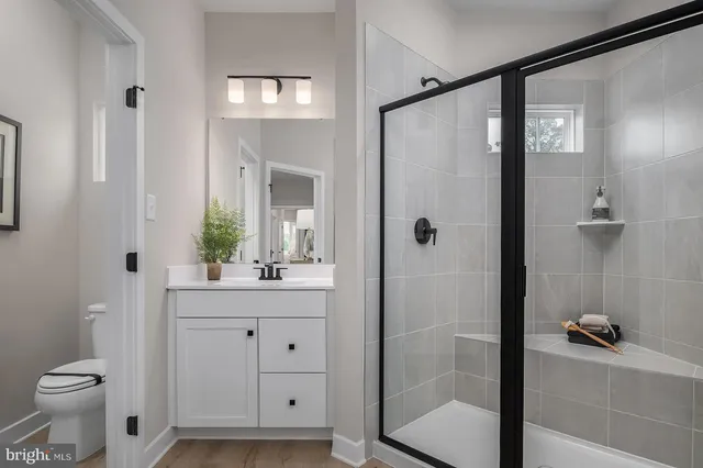 a bathroom with a shower sink vanity and toilet