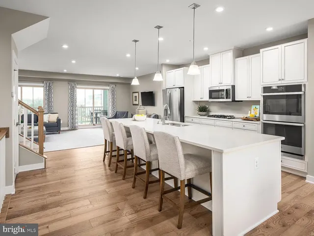 a large kitchen with kitchen island a dining table and chairs