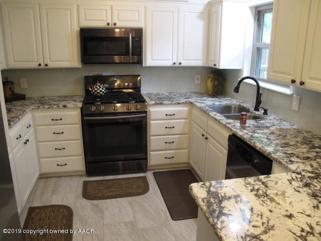 3305 Bedford Road Amarillo, TX 79106 - Photo 3 of 21 a kitchen with a stove a sink and a microwave