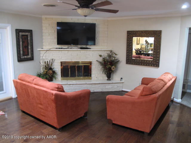 3305 Bedford Road Amarillo, TX 79106 - Photo 4 of 21 a living room with furniture a flat screen tv and a fireplace